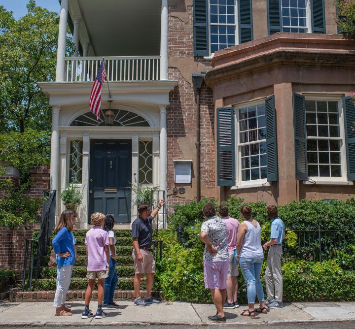 Tour guide and group walking through Charleston. 